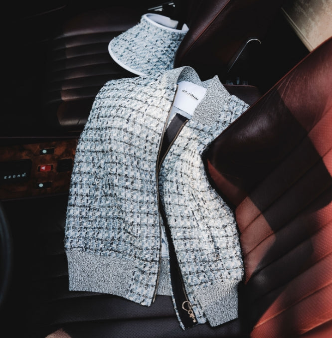 Gray textured St John Knits Malbon jacket with a brand tag inside a car.