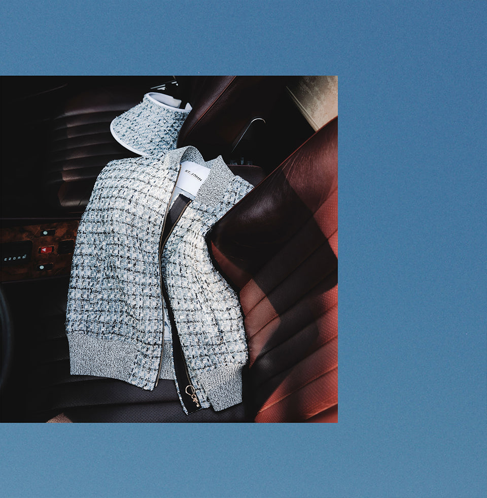 Gray textured St John Knits Malbon jacket draped over a car seat with a blue background